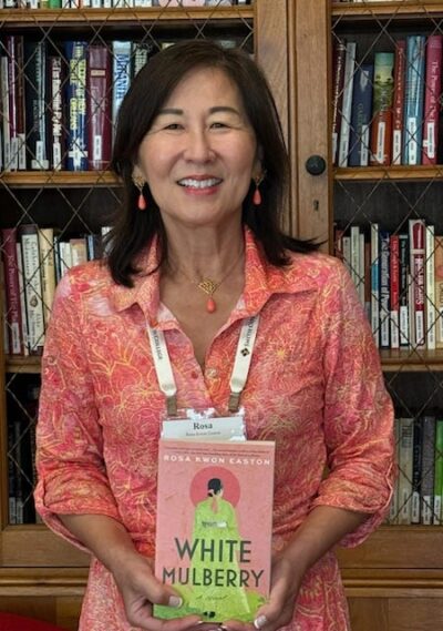 Rosa Kwon Easton holding her first novel, White Mullberry